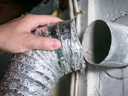 Technician cleaning a dryer vent to improve home safety and efficiency