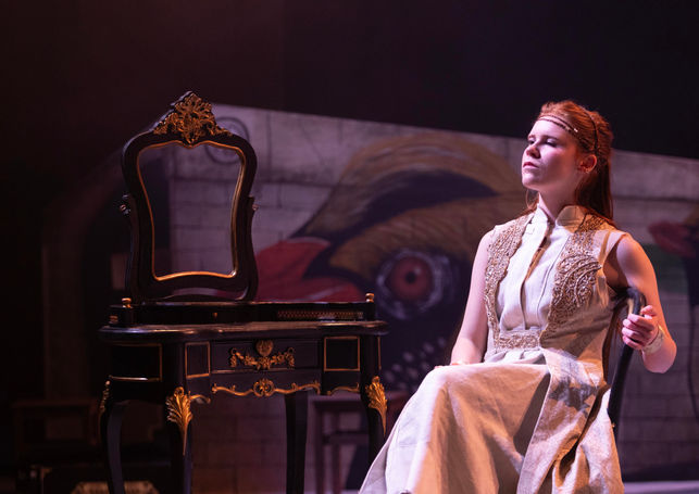 A woman in white looking out to the audience