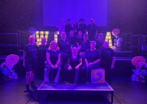A photo of the whole crew lit in purple