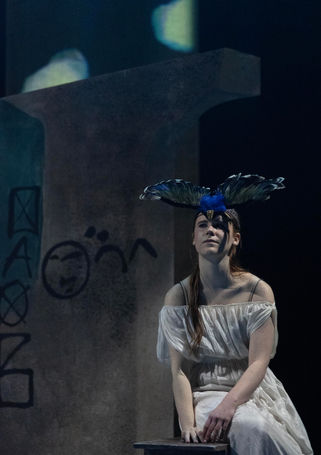 A woman in white, with a blackbird headdress on