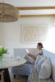 Woman reading in a comfortable dining nook.