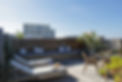Rooftop patio with lounge chairs and wooden seating