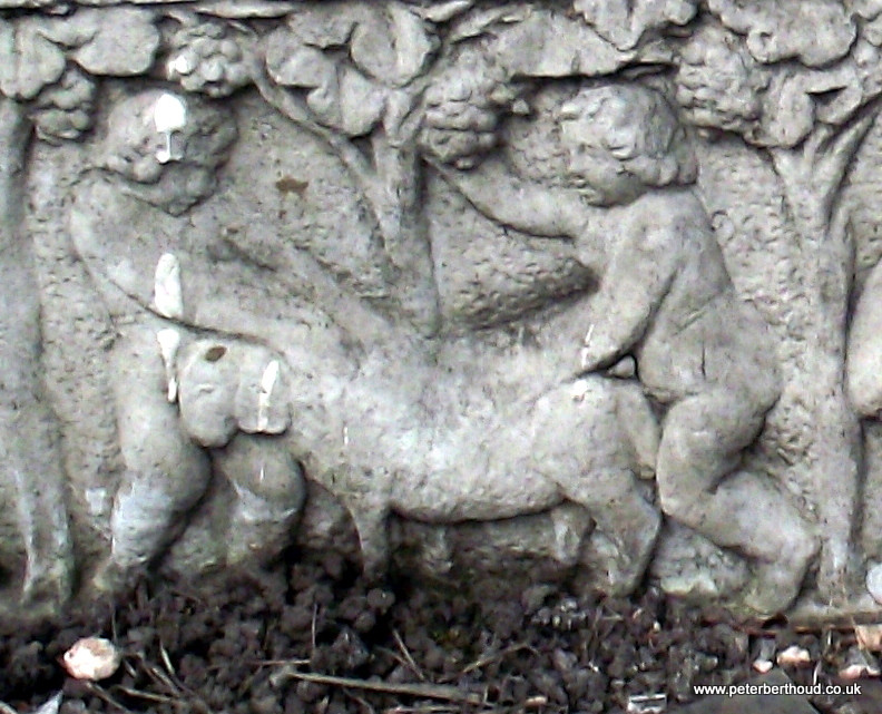 Two cherubs and a sheep engaged in dubious activity on the planting trough