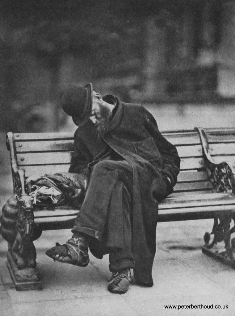 Homeless man asleep on a bench, the Embankment in the City of London, mid 1930s.