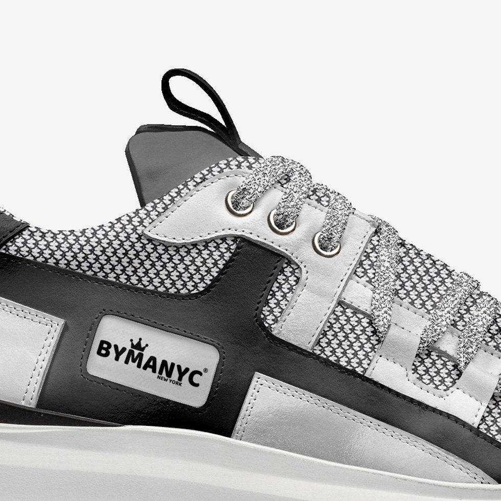Miniatura: Close-up of a stylish silver and black sneaker with BYMANYC logo.