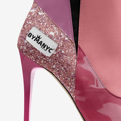 Close-up vibrant high-heeled boot with BYMANYC tag, glitter, and pink hues.