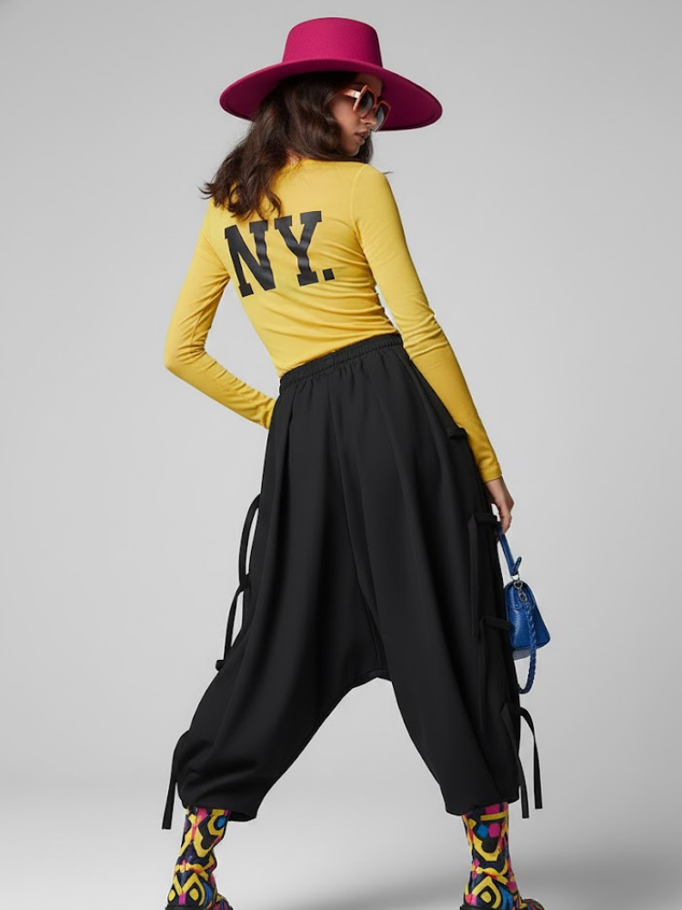 Miniatura: Woman modeling yellow NY shirt, black pants, pink hat, blue bag.