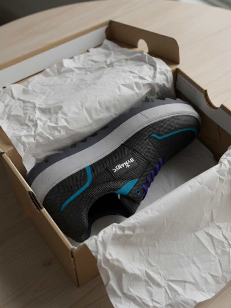 Dark Sabotage sneaker with blue accents, purple laces, in open shoebox.