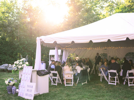 Wedding guests talking at reception tables during dinner with seating chart nearby