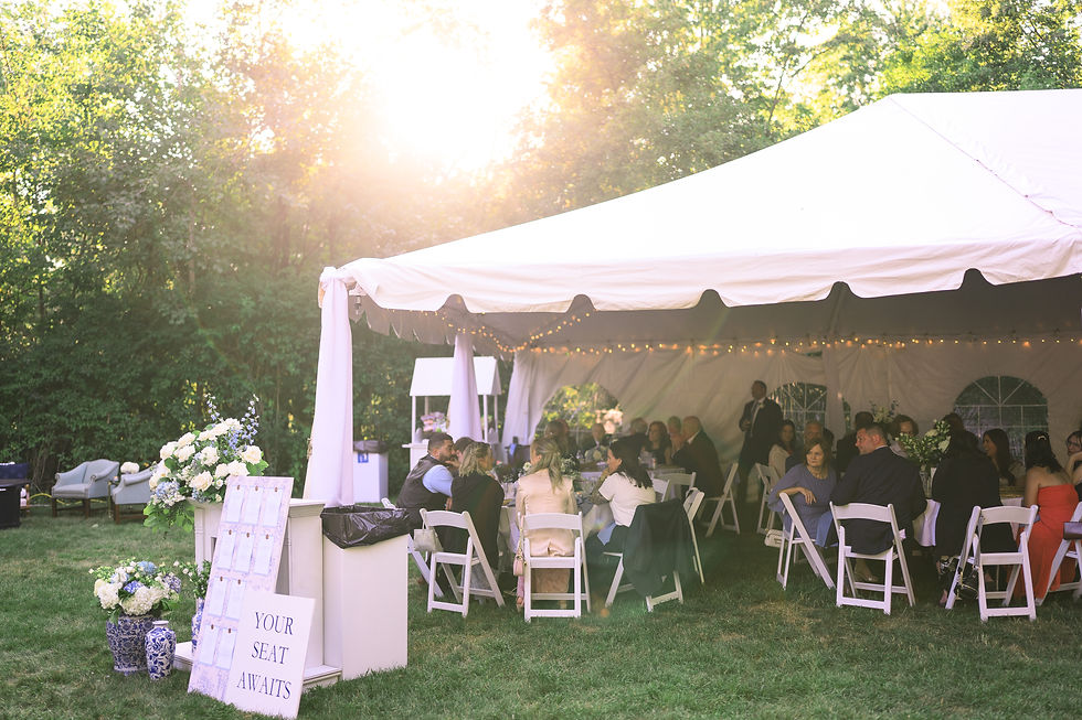 Wedding guests talking at reception tables during dinner with seating chart nearby