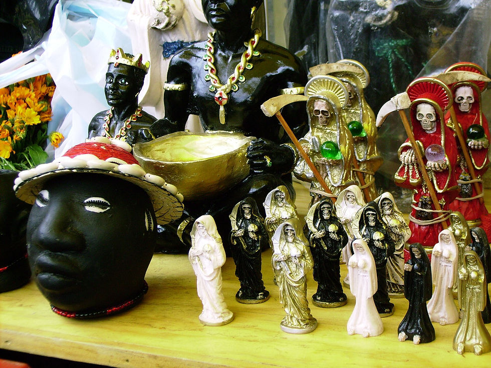 Numerous statues sit upon the busy market counters with other Latin American items.