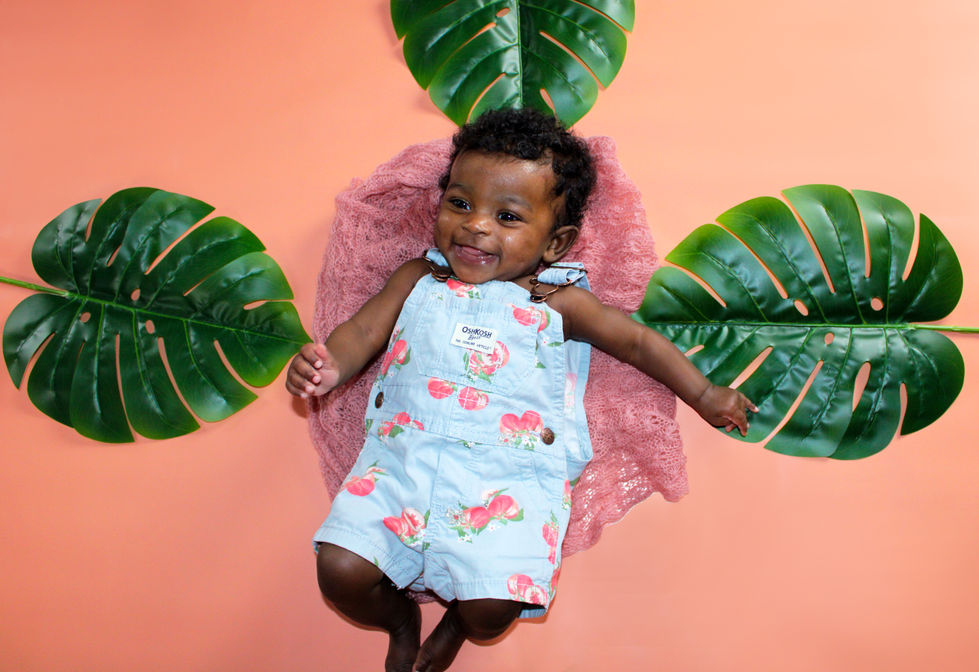 Summer background wiht tropical palms and baby in overalls.
