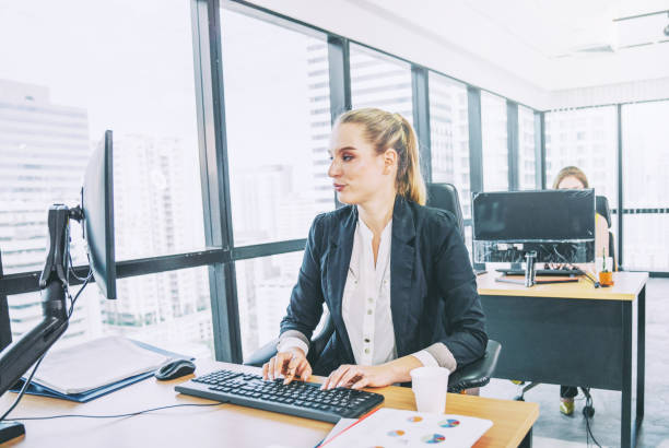 American woman working at a computer performing AI content moderation and data labeling tasks, representing the hidden U.S. labor behind AI development.