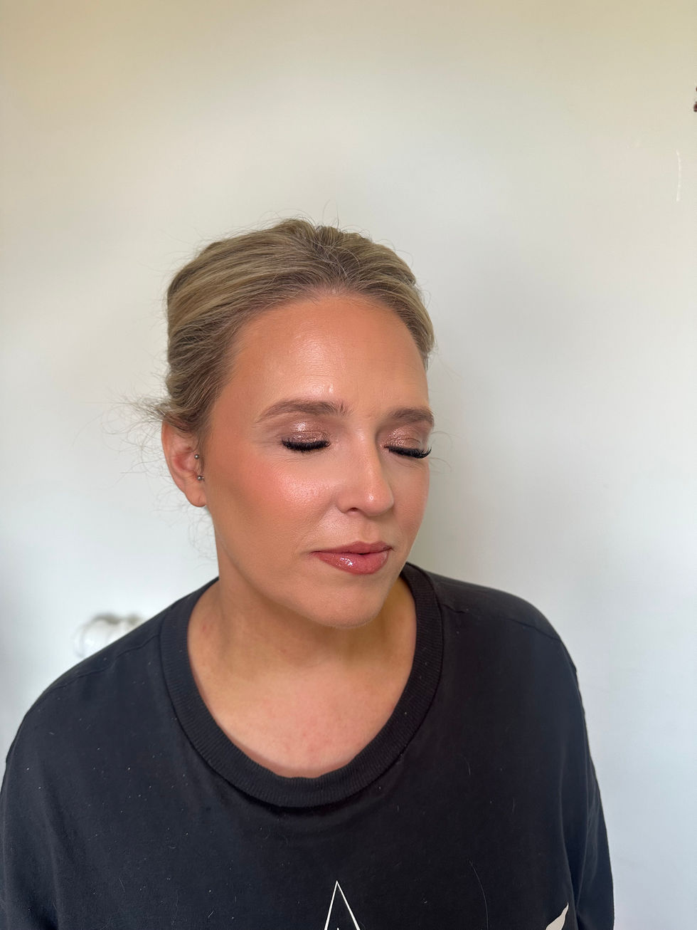 a woman wearing a black shirt has her eyes closed
