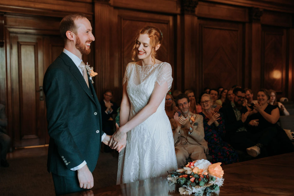 a bride and groom hold hands during their wedding ceremony