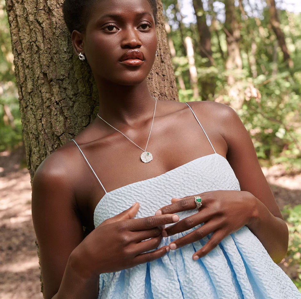 a woman in a blue dress is leaning against a tree