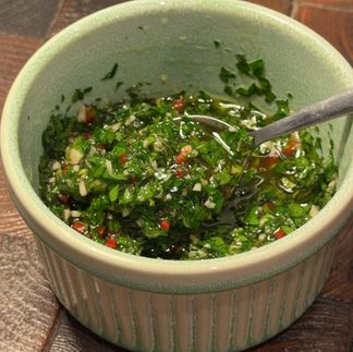 Close up of spiced chickpeas topped with golden honey roasted chicken and vibrant green salsa verde