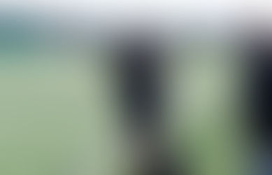 A player performs a sled drag on a 3G pitch as part of a recovery-focused session. Ed stands alongside offering encouragement and guidance during the exercise.