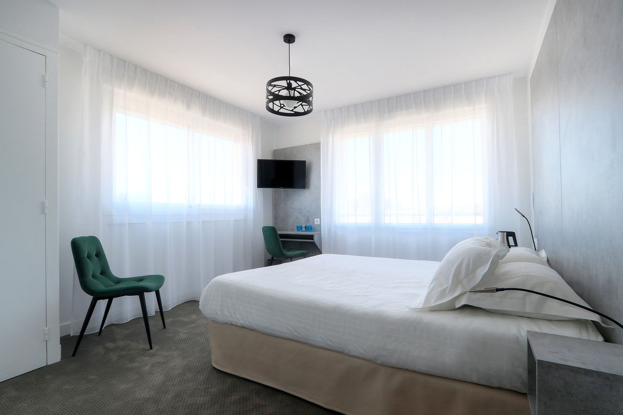 Classic Room with double bed and two green armchairs at the Hotel Le Bellevue in Quiberon