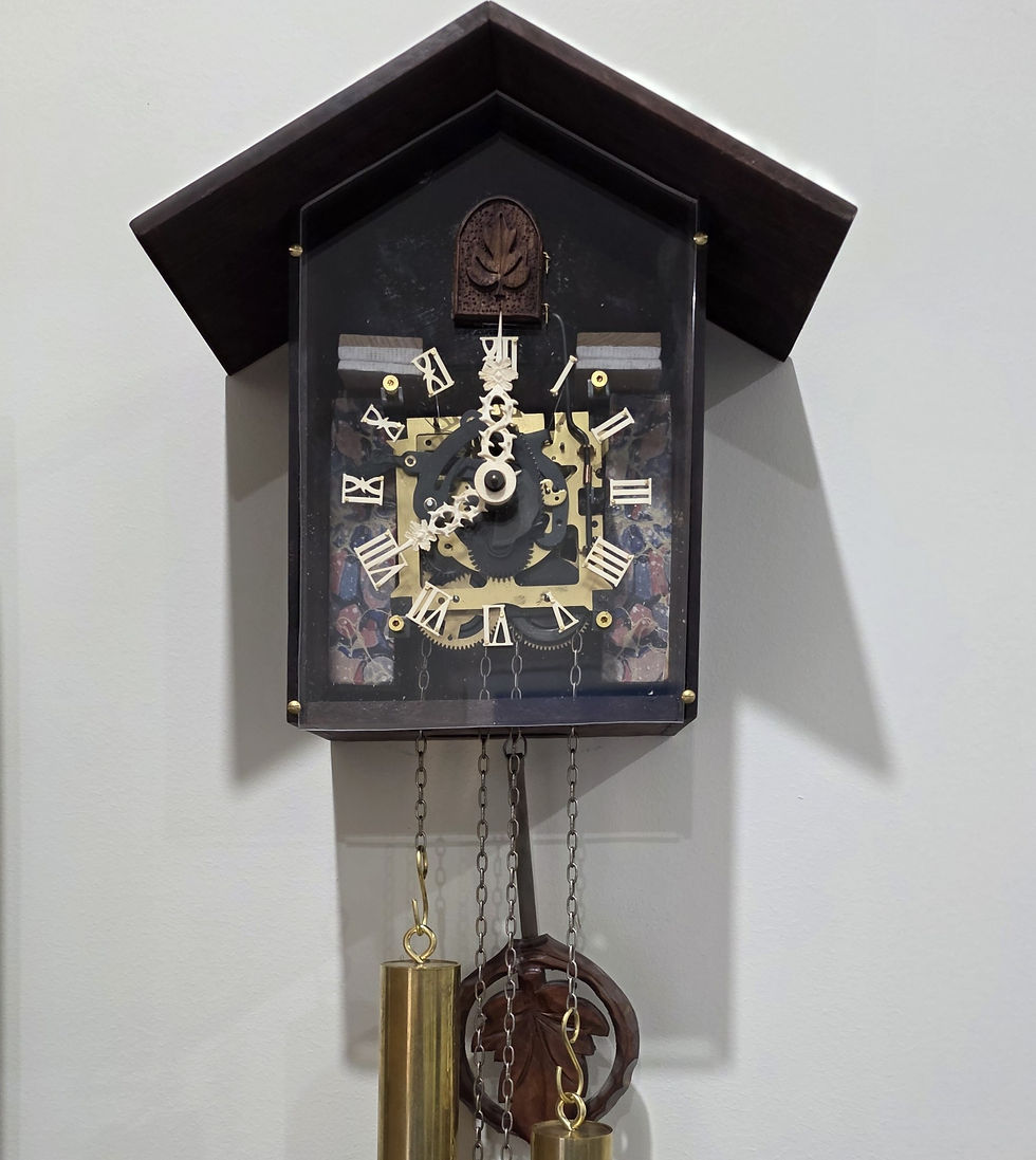 Antique-style cuckoo clock with Roman numerals and intricate gears, adorned with brass weights and a decorative pendulum, hangs elegantly on the wall.