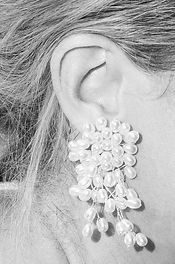 Detail très mode et fine art sur une boucle d'oreille en perle de la mariée lors d'un mariage très chic provencal