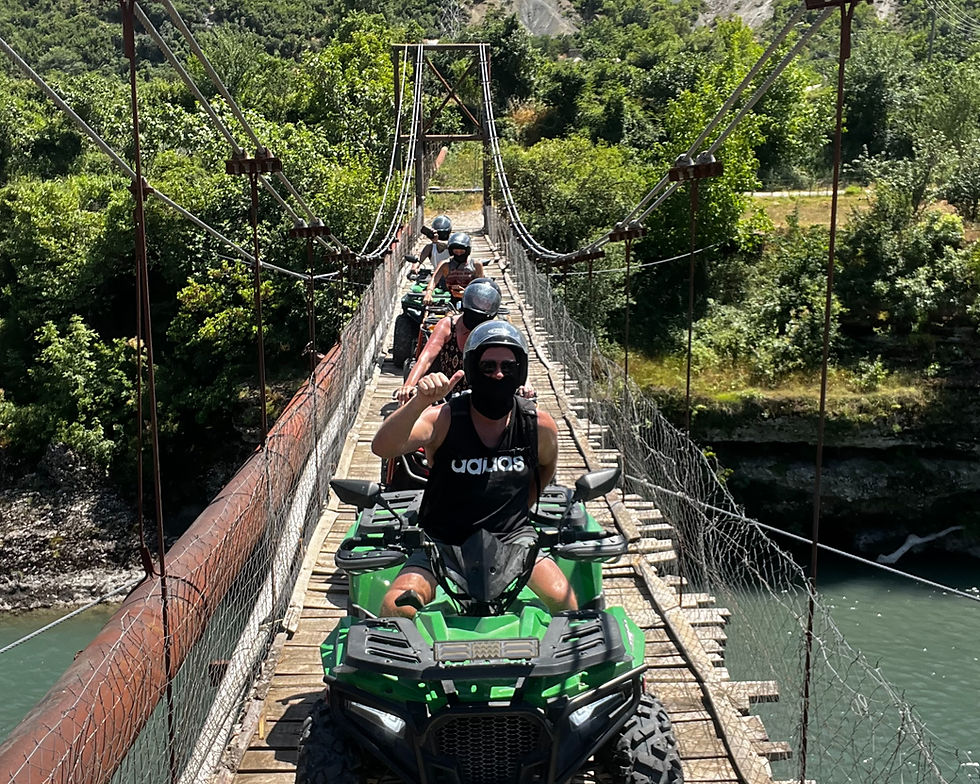 Quad bike crossing a river during an off-road tour in Përmet