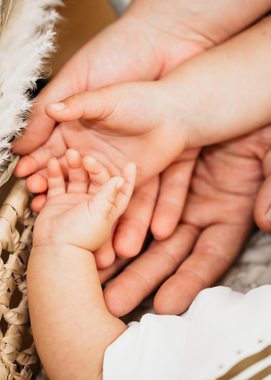 Detailaufnahme der zarten Babyhände beim Newborn-Shooting, eingefangen im sanften Licht, ein Moment voller Liebe und Geborgen