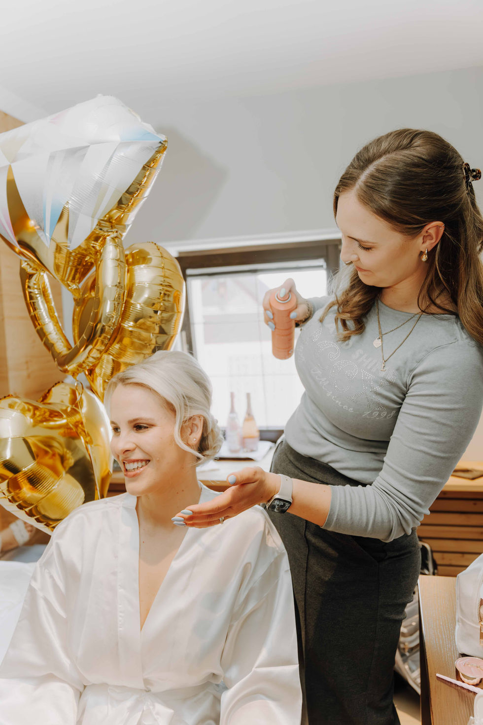 Braut im weißen Seidenmantel beim Styling