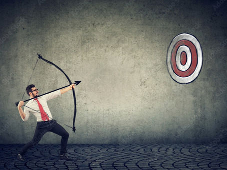Man in white shirt and red tie aims a bow at a target on a grunge wall. Stone-patterned floor. Determined mood.