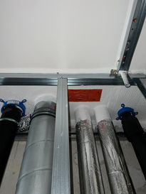 Rohrleitungen und Isolierung in abgehängter Decke