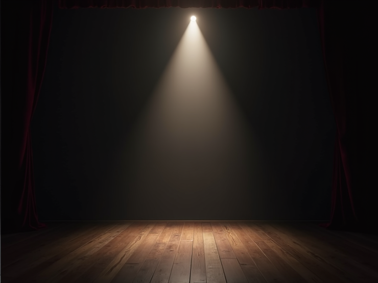 Vintage theatre spotlight casting illumination across dark stage.