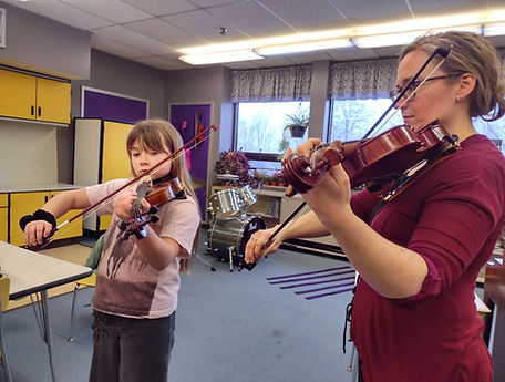 Teacher and student playing violin during a lesson