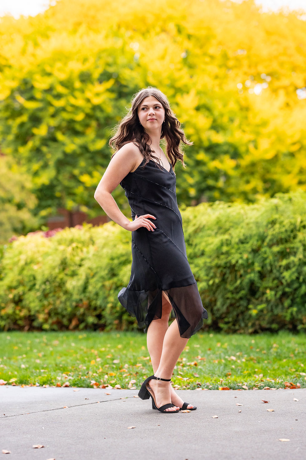 Photo of girl in prom dress for local Tacoma Public School dance with brick from UPS college campus