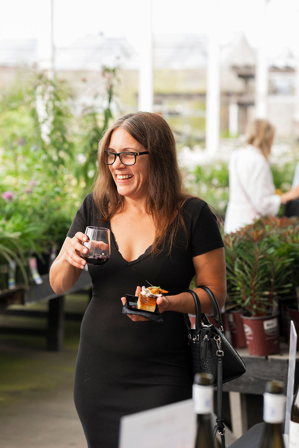 women holding a glass of red wine laughs