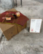Cardboard boxes with a red cloth, toast, drink, and text stand. Text: Mornings I Long For. Industrial setting. Cozy mood.