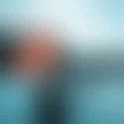 In this evocative photograph, a local boy from Bequia is captured carrying a vibrant diving flag. The blurred background, featuring the serene waters and majestic hills of Bequia, adds a sense of motion and depth to the image. The diving flag, with its distinctive colors, stands out prominently, symbolizing the island's rich connection to the sea and diving culture. The scene beautifully encapsulates the spirit of the local community and their harmonious relationship with the ocean.