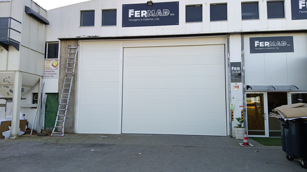 Instalação de portão seccionado industrial RAL 9010 em Fermad