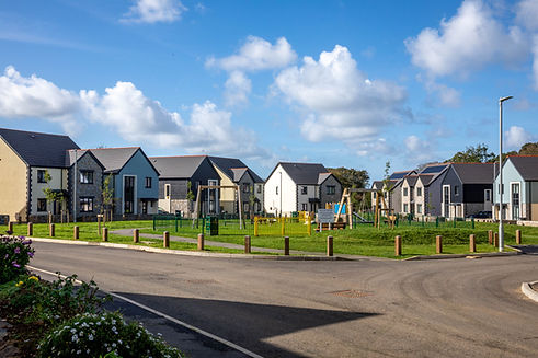 New homes overlooking landscaped lawns, young trees and a play area at Tregenna Lea, Camborne