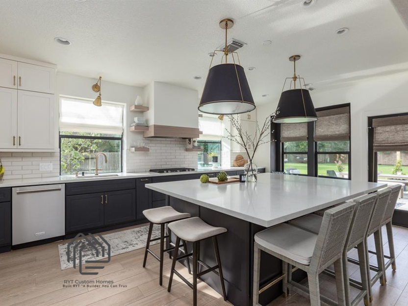 Square kitchen island, white counter tops, dark cabinets and bar stools. 