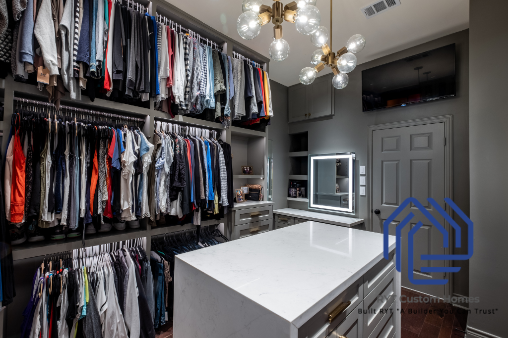 custom closet with center island with storage drawers, and clothing racks