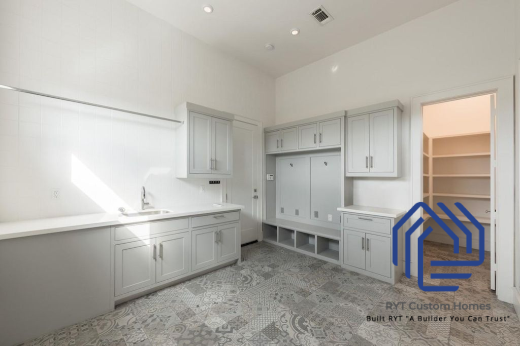 Modern utility room with sink, counter tops, built-in cabinets and shelves.
