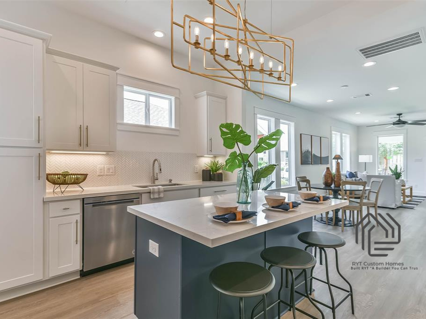 Kitchen with island, barstools, opening to dining and living area. 