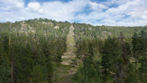 Beautiful view of a mountain with powerline right-of-way trimmed on a sunny day.