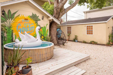 The outdoor soaking tub with a giant inflatable swan, floating casually on the surface on a bright, sunny day.