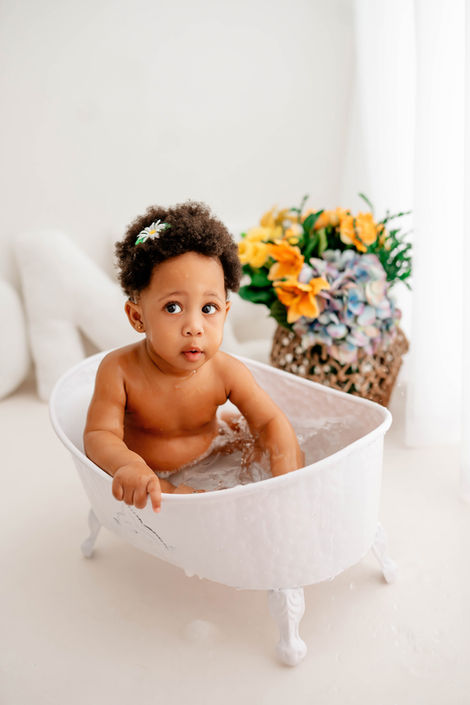 Smiling one-year-old baby during a minimalist cake smash photoshoot. | Lächelndes Baby beim Cake Smash Fotoshooting zum ersten Geburtstag.