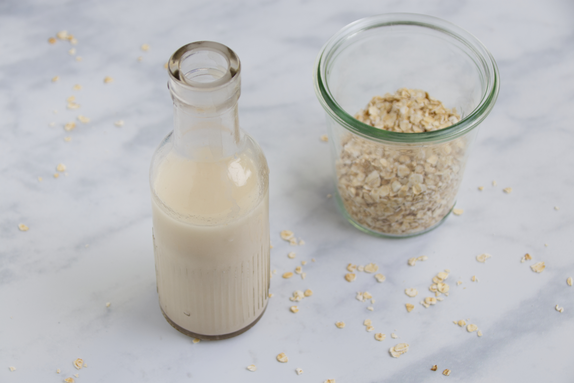 Hafermiclh steht neben Haferflocken