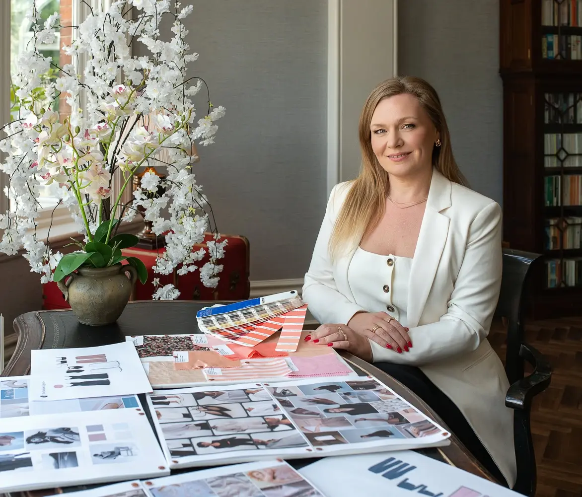 Michelle Ramsay, fashion designer, mentor and startup consultant and designer, sitting at a table with designs and tech packs, supporting first-time founders to launch clothing brands.