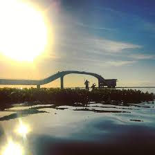 Ponte ao pôr do sol, pessoas silhuetadas