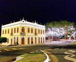 Prédio histórico iluminado à noite, árvore enfeitada