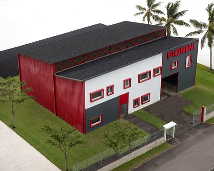 Factory building, metal siding, red and white paint, dark gray roof,  rectangular windows,